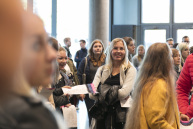 Eine Frau im Mittelpunkt in einer lockeren Gruppe die in die Kamera schaut