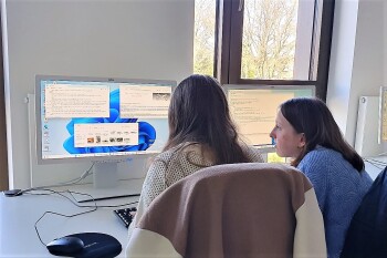 Zwei Personen blicken auf einen Bildschirm