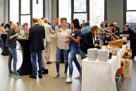 Blich in den Konferenzbereich mit Buffet und Menschen.