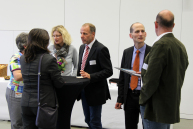 Menschen stehen im Konferenzbereich der FH und unterhalten sich.