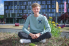 Jannis Schröder sitzt vor der FH Bielefeld