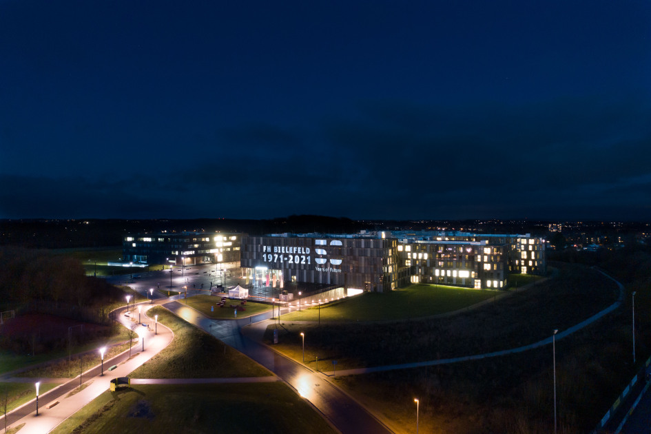 Blick auf das illuminierte Hauptgebäude der FH Bielefeld