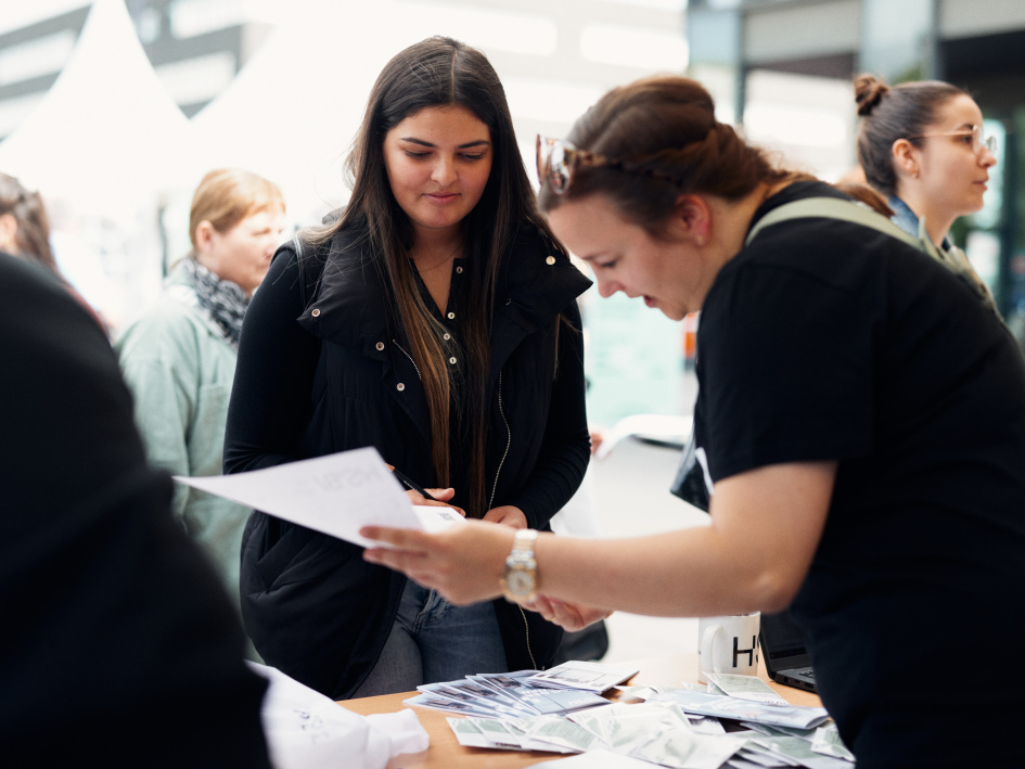 Eine Frau informiert sich am Infozelt