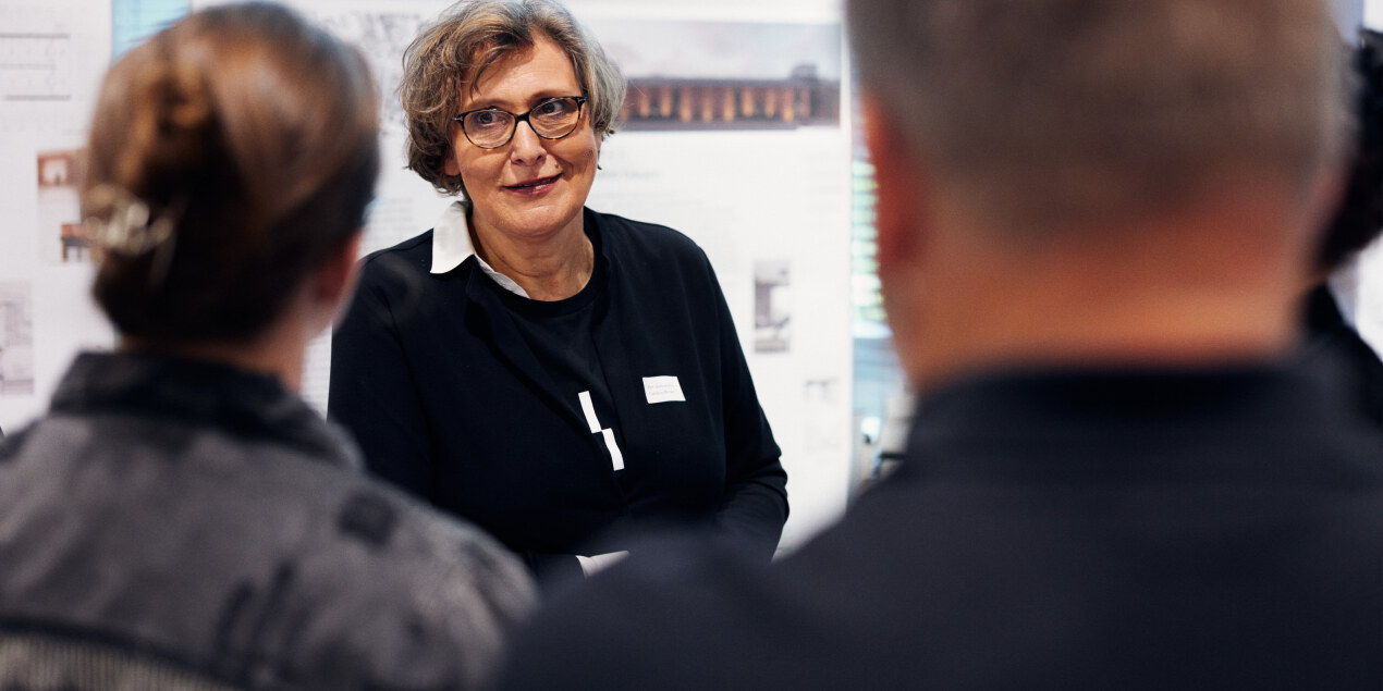 Eine Frau im Gespräch mit Personen