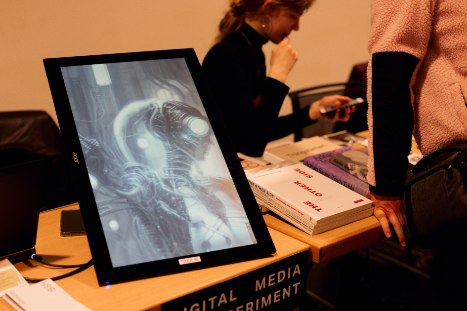 Auf einem Tablet des Fachbereichs Gestaltung ist ein Foto von einem Cyborg zu sehen auf dem Tablet klebt ein Zettel mit der Aufschrift Touch me