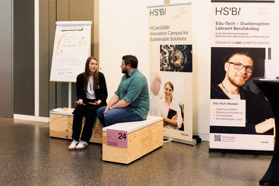 Auf der InCamS Science Bench sitzen eine Mitarbeiterin und ein besucher und unterhalten sich