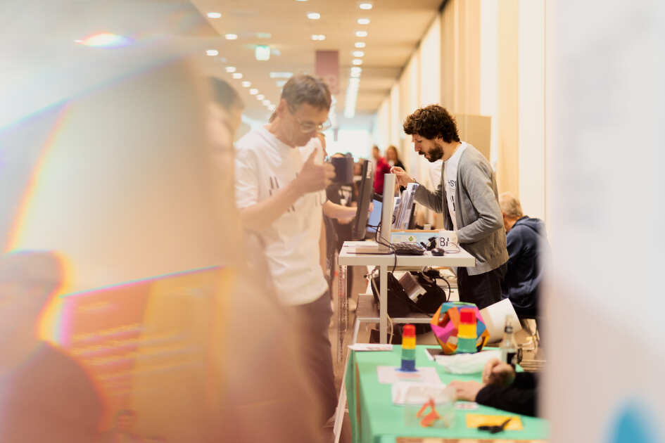 Foto: Ein Mitarbeiter der HSBI steht hinet einem Infostand