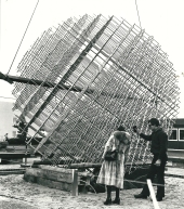zwei Personen stehen vor dem kugelförmigen Kunstwerk