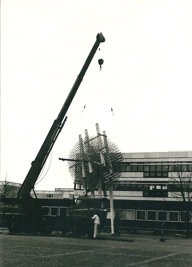 Das Kunstwerk wird am Kran hängend transportiert.