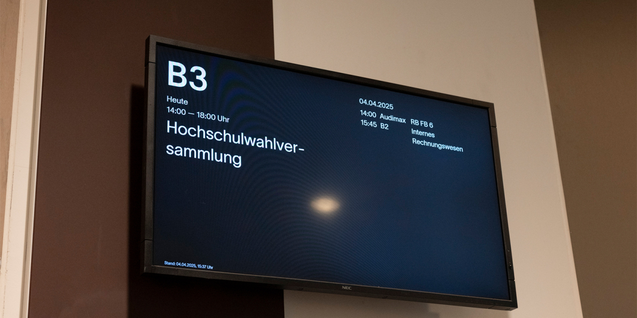 Foto: Bildschirm vor dem Hörsaal B 3 mit der Hochschulwahlversammlung angekündigt