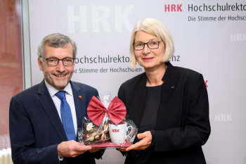 Walter Rosenthal und Ingeborg Schramm-Wölk stehen nebeneinander. Er überreicht ihr ein Präsent