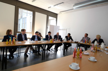 Acht Personen an Tischen im Seminarraum