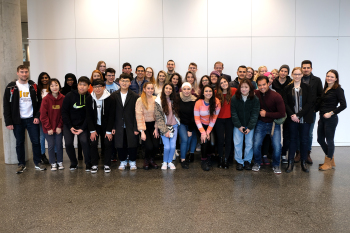 Eine Gruppe Menschen steht vor einer Wand