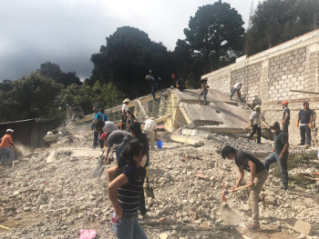 Menschen räumen Schutt auf.