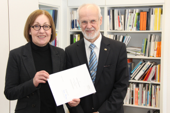 Prof. Dr. Beate Rennen-Allhoff  übergibt Prof. Dr. Wolf-Berend Busch die Urkunde.