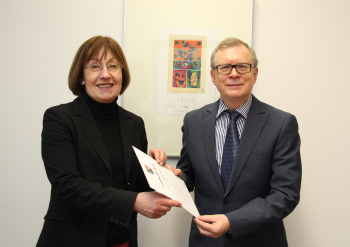 Prof. Dr. Beate Rennen-Allhoff überreicht Prof. Dr. Roland Friedrich die Urkunde.