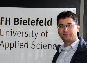 Professor Carsten Gips steht vor dem Eingeng der FH Bielefeld.