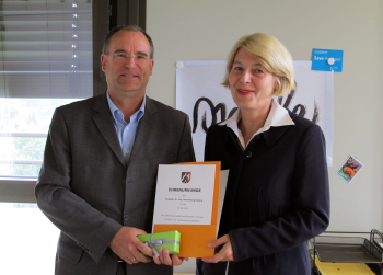 Prof. Dr. Hans-Georg Gülzow bekommt die Urkunde von Prof. Dr. Ingeborg Schramm-Wölk überreicht.