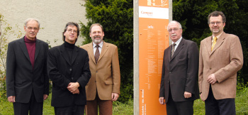Die fünf Professoren stehen neben einer Stehle mit Informationen zum Campus Minden.