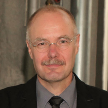 Porträtfoto von einem Mann mit Hemd, Krawatte, und Jacket.