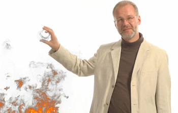 Prof. Loviscach löscht mit einem Glas Wasser ein Feuer. Es handelt sich um eine Computeranimation.