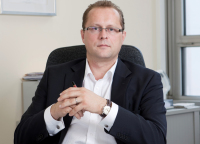 Marcus Miksch sitzt am Schreibtisch.