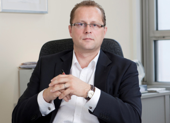 Marcus Miksch sitzt am Schreibtisch.
