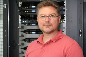 Prof. Dr. Christian Schröder steht vor einem Rechner-Cluster