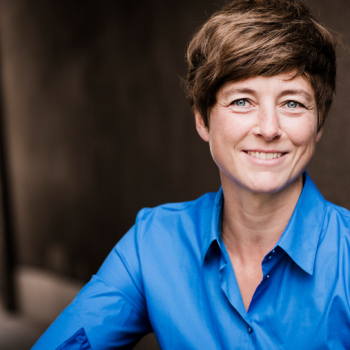 Eine Frau blickt in die Kamera.