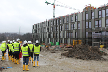 Eine Gruppe von FH-Angehörigen besichtigt den Fortschritt auf der Baustelle, hier die Fassade am Bauteil D.
