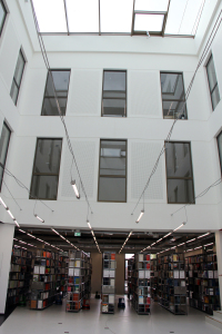 Foto vom Lichthof mit gefüllten Bücherregalen der Bibliothek am Campus Minden