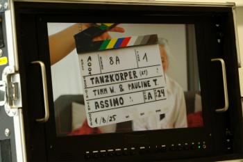 Foto: Eine Filmklappe auf der Tanzkörper steht