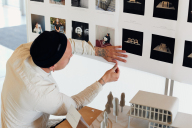 Ein Student bringt Fotos über einem Model an