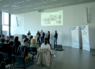 Die Projektleitenden stehen vorne im Konferenzsaal