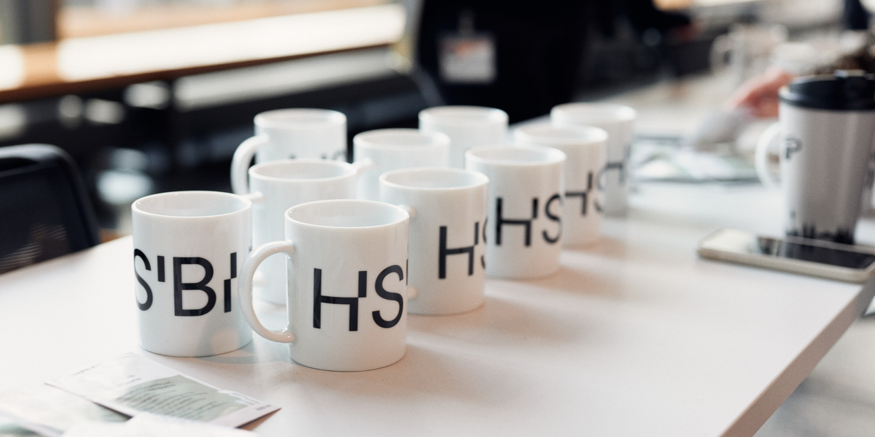 Mehrere Tassen mit HSBI Logo