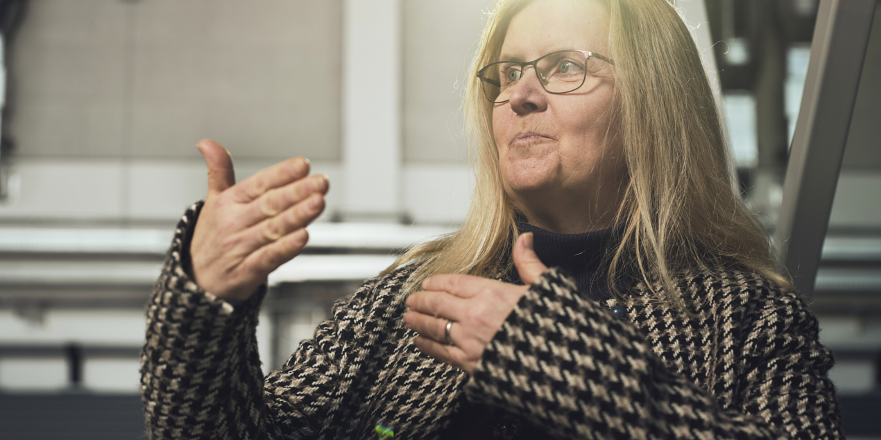 rträtfoto von Professorin Doktor Eva Schwenzfeier-Hellkamp im Hintergrund sieht man die eine graue Wand und eine Treppe