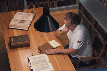 Prof. Dr. Marc-Oliver Schierenberg liest in dem Notizbuch von Leonardo da Vinci.