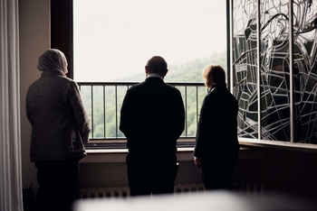 Dr. med. Turan Devrim, Prof. Dr. Katja Makowsky und Dr. Havva Mazı stehen gemeinsam neben einem geöffneten Fenster und schauen hinaus.