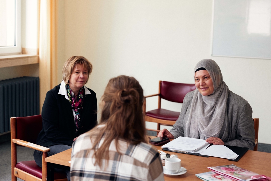 Prof. Dr. Makowsky und Prof. Dr. Mazi sitzen mit einer Patientin am Tisch und interviewen sie.