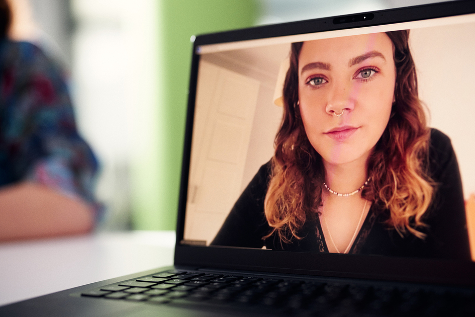Auf einem Laptop ist eine Frau im Zoom-Meeting zu sehen