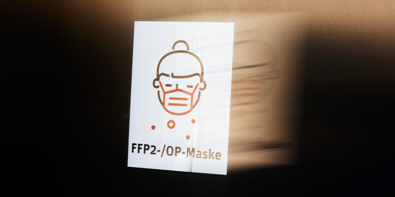 Plakat mit einem Symbol für das Tragen von FFP2 und OP-Masken