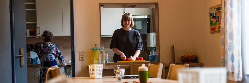 Emely Westfeld steht in der Küche und schneidet eine Tomate.