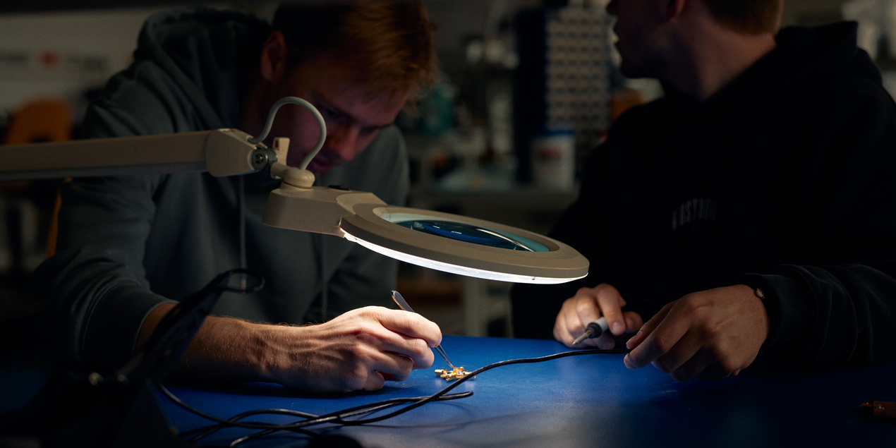 Zwei Studierende arbeiten an einer Platine